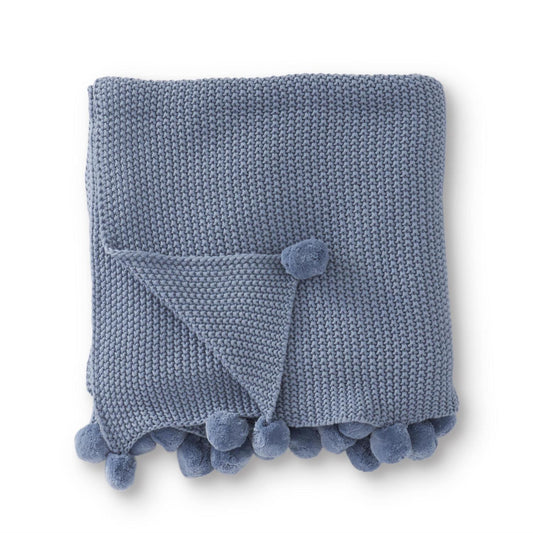Colcha tejida celeste con borde de pompones